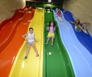 kids sliding down a rainbow slide