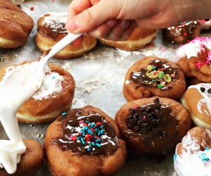Icing is drizzled over a collection of mini doughnuts