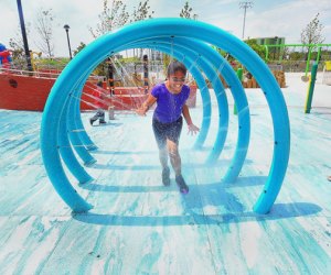 Girl running through tunnel of water spray