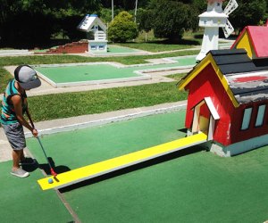 Mini-Golf Courses on Long Island boy putting in a mini golf course at Drossos Miniature Golf 