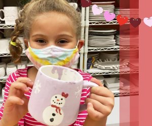 girl with a pottery mug at A Maze In Pottery Westchester Birthday party