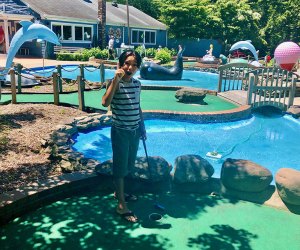 Boy on a mini-golf course in summer sunshine