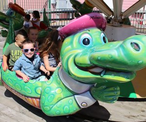 Smiling preschoolers ride the alligator at Jenkinson's