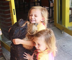 Two girls hug a bear at Bareburger