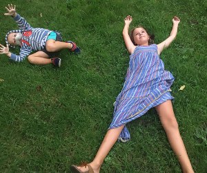 Boy and girl sprawl in grass at the Brooklyn Botanic Garden