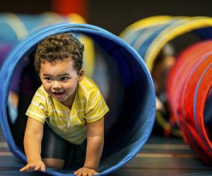 Baby crawling through tunnel. Photo courtesy of Canva