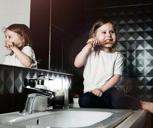 tricks for how kids can conserve water girl brushing her teeth at the sink