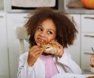 Girl devouring turkey, just like in this Thanksgiving Joke for kids!