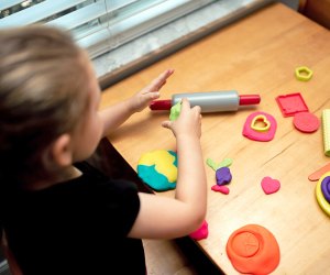 Girl playing with playdough to combat boredom.