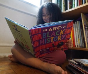 Don't be bored, this girl is smiling because she's reading a great book.