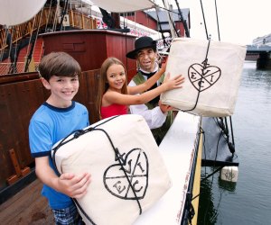 Image of kids throwing tea into Boston Harbor- 100 Things to do in Boston