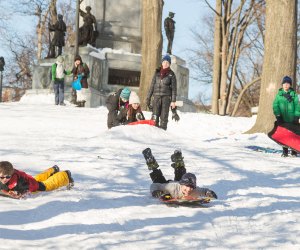 Photo of kids sledding on Flagstaff hill in Boston.