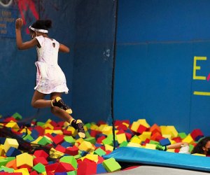 Girl jumping into a foam pit at a trampoline park near NYC