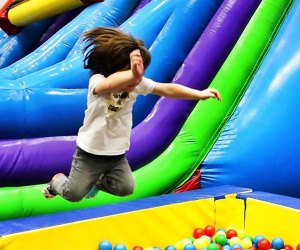 Kid jumping in a ball pit at Bounce N Play trampoline park in Queens 
