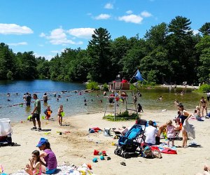 Photo of families lounging on beach at top swimming lake near Boston