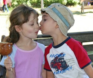 Two kids share a caramel apple. Photo by Meghan Rose