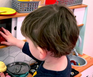 child playing in toy kitchen