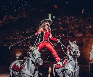 woman performs a horse a show in front of an audience Dolly Parton's Stampede