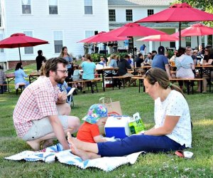 Boston Breweries: Image of a family relaxing in the grass at a Notch Brewery beer garden.