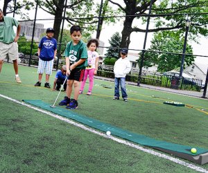 Children learn to play golf during the City Parks free summer sports programs in NYC