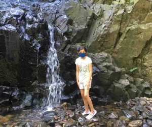 Girl stands in the rocks near Hemlock Falls