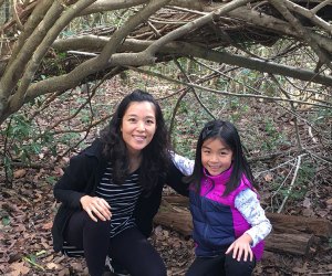 mom and daughter hiking through a woods tunnel