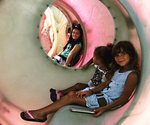 Little girls ride on the SeaGlass Carousel a fun outing and one of our top things to do with preschoolers in NYC