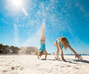 girls doing handstands on the beach