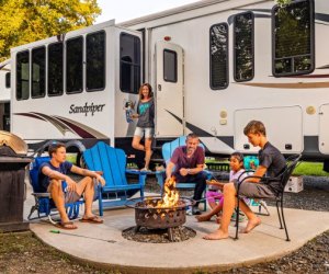 Ultimate Road Trip Planner: How to Have the Perfect Family Road Tripfamily rv camping sitting by a fire