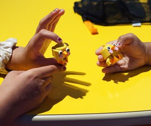 Little hands hold Lego chick creations