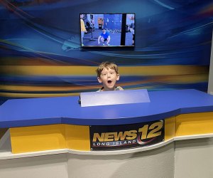 boy sitting at a news desk at LICM