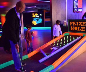 Mini-Golf Courses on Long Island dad play glow golf with kids