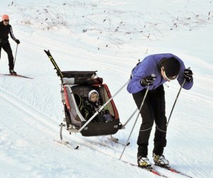 this mage shows a family cross country skiing.