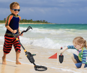 kids using metal detector on the beach
