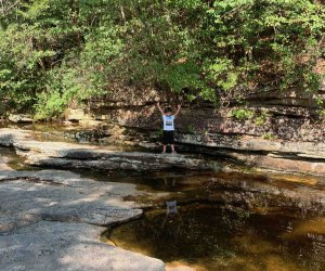 A boy poses on a rock outcropping near Awosting Falls in Lake Minnewaska State Park and Preserve