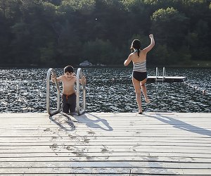 kids jumping off a dock into a lake
