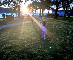 Families gather at Northport Park as the sun sets on the scenic Northport Harbor. Photo by the author