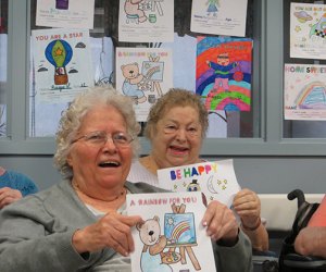Senior citizens smile after receiving their Color A Smile cards