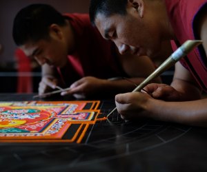 Watch the skill and precision of the Mandala Sand Painting artists at work. Photo courtesy of Asia Society of Texas.