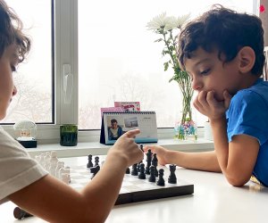 two boys playing chess LI spring break activities