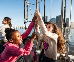 NYC boat ride with kids raising the sail on a schooner