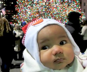 Best things to do in NYC with babies: Baby poses in front of Rockefeller Center Christmass Tree