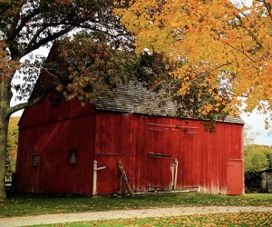 Old Bethpage Village Restoration's red barn and fall foliage make a beautiful photo background
