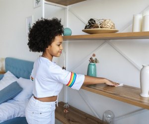 a girl dusting a shelf