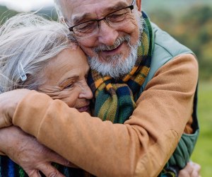 an older couple hugging 101 Questions To Ask Grandparents About Their Lives