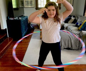 girl hula hoops inside indoors