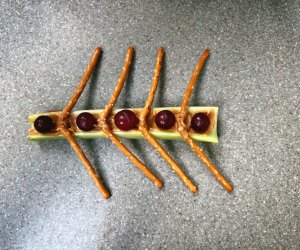 Olympic rowers snack with celery boat, grape people, and pretzel oars held together with peanut butter.