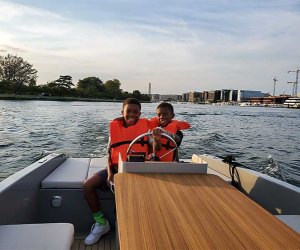 No license needed to drive this boat - kids driving a motor boat.