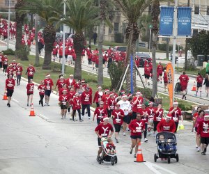 Watch thousands of Santas take to the street during this holiday race. Photo courtesy of Santa Hustle Race Series, LLC.