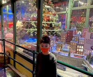 boy at macy's santaland in front of model trains christmas trees